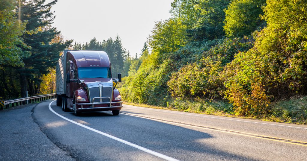 Red truck on country road making money as an owner operator