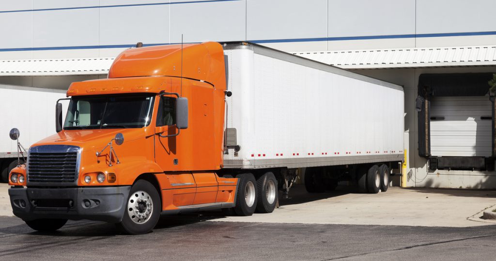 Orange truck parked in dock using TruckLogics TMS