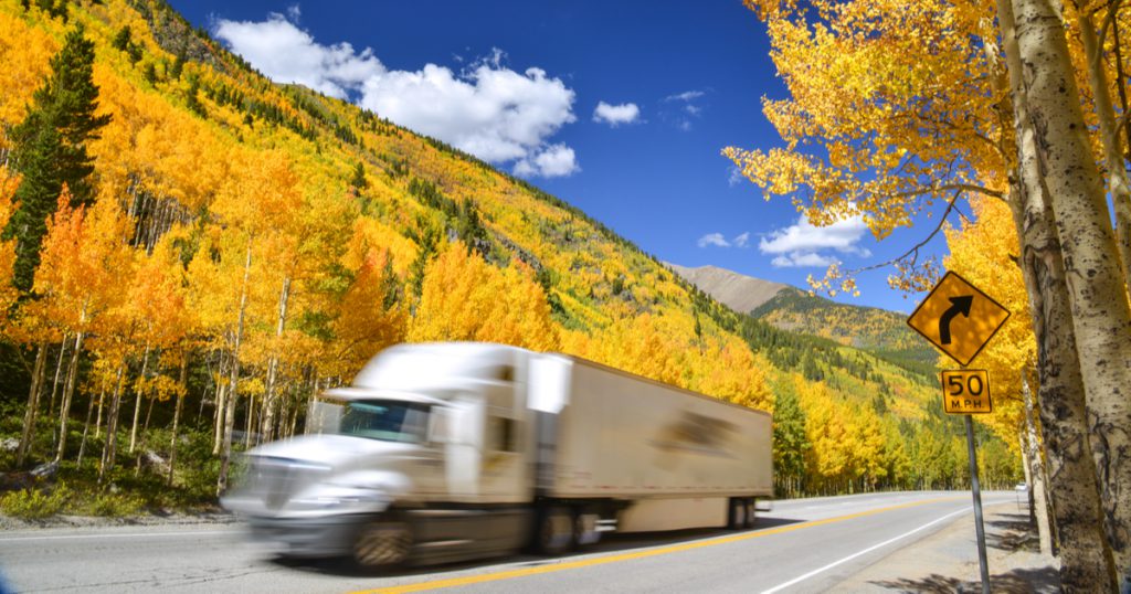 Company driver in fall using TruckLogics mobile app trucking management software for drivers